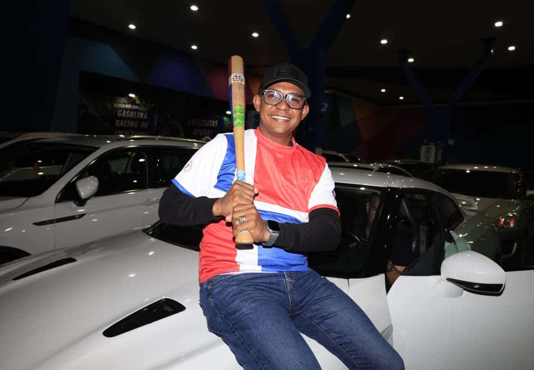 Con la bandera y un bate en la mano, este joven muestra el orgullo por el equipo dominicano.