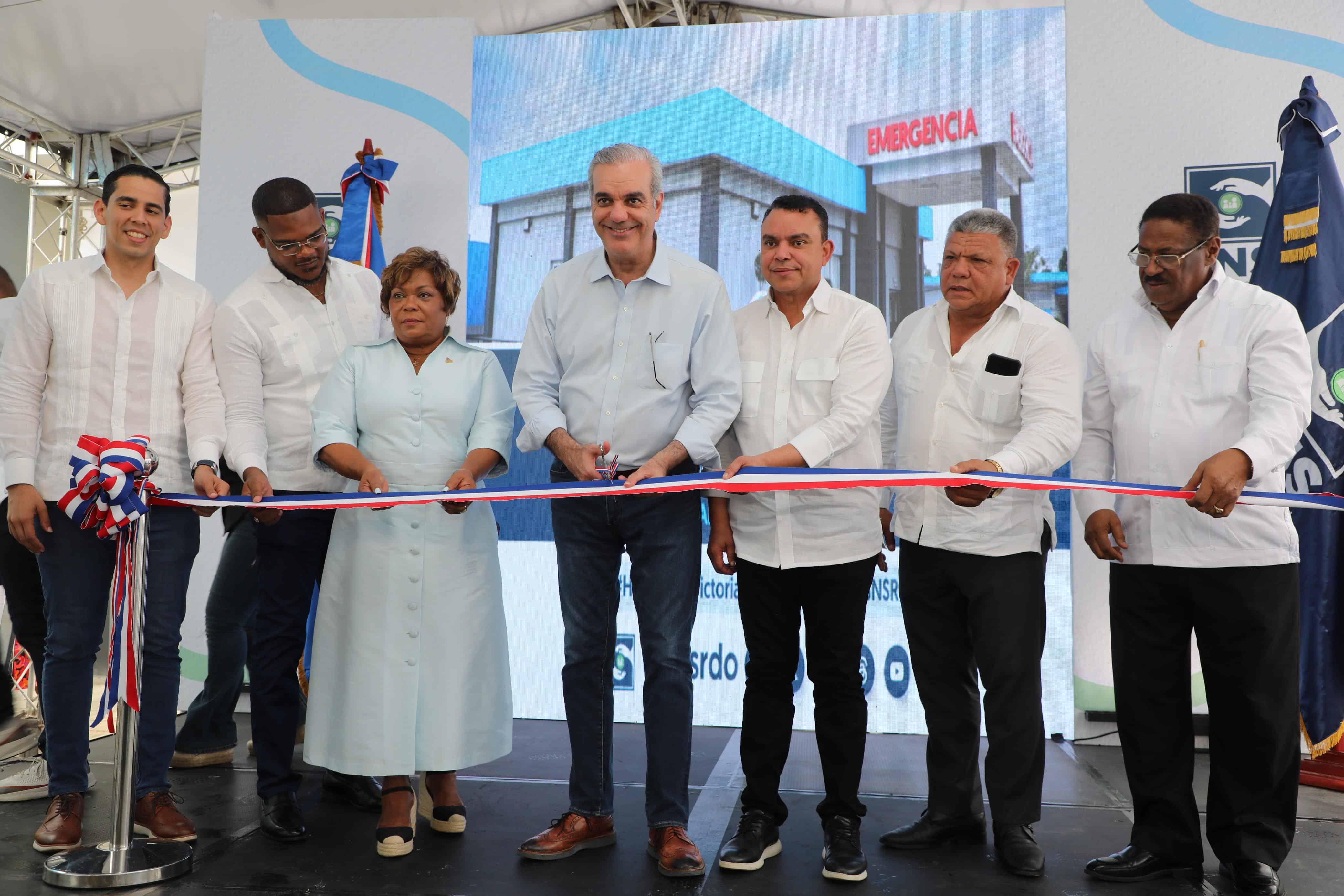 El presidente Luis Abinader (al centro) corta la cinta, que deja inaugura el remozamiento del hospital, junto a otros funcionarios.