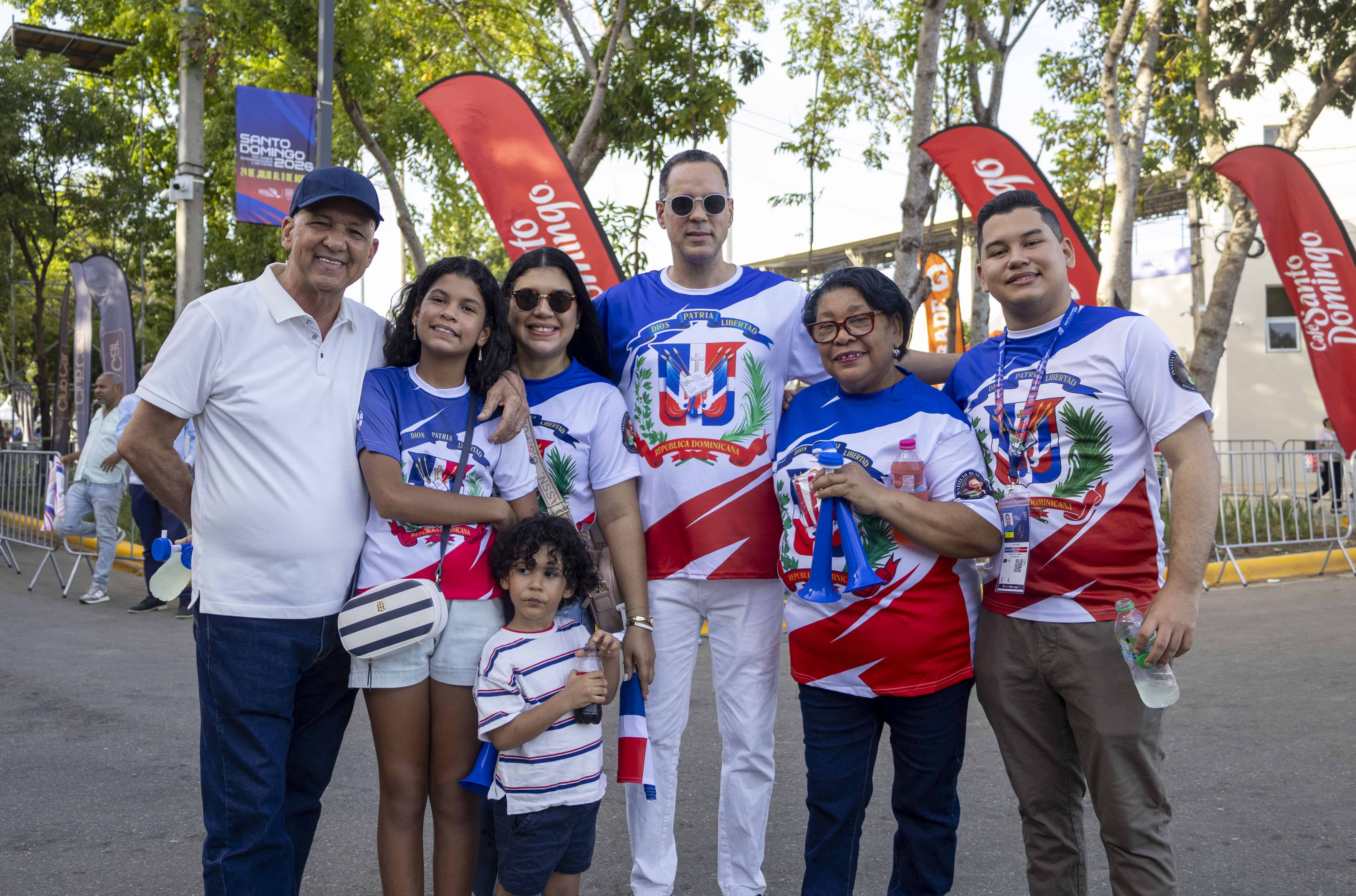 Una familia asiste con banderas y vestimenta alusiva a la República Dominicana a la ceremonia inaugural de los Juegos Centroamericanos y del Caribe Santo Domingo 2026.