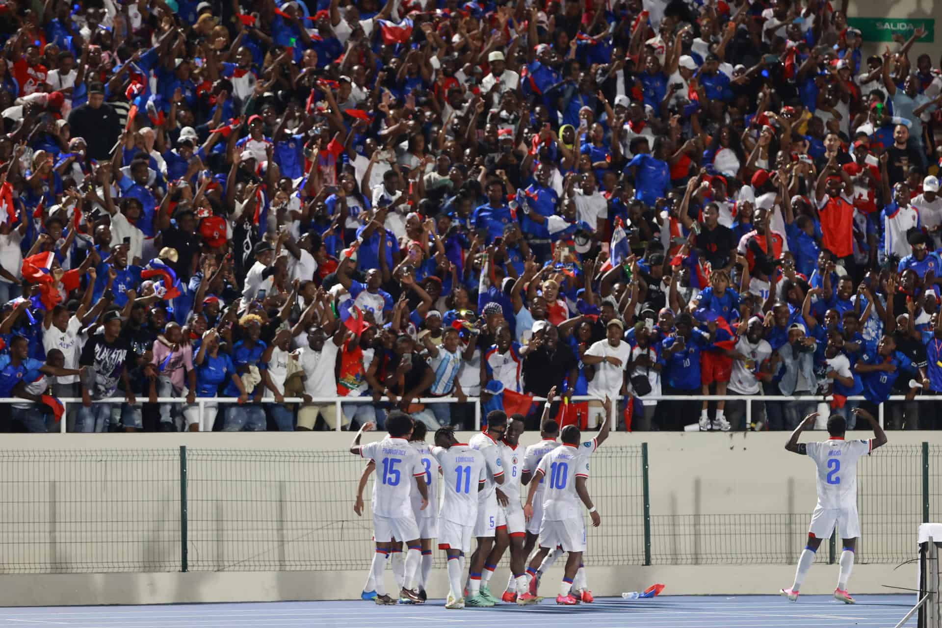La selección de Haití celebra la victoria con los fanáticos que presenciaron el partido. 